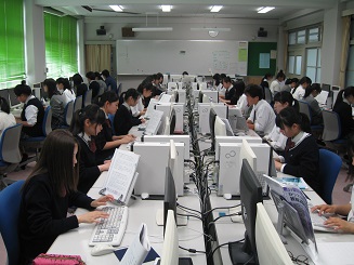 生徒がテキストを見ながらパソコンにむかっている写真